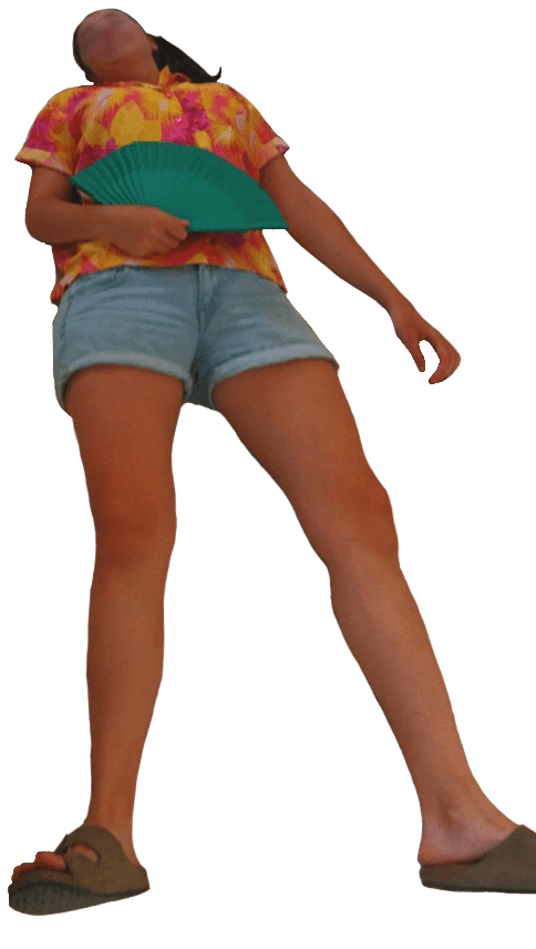 A photo of me in Cuba laying down, wearing a pink and yellow Aloha shirt, light denim shorts. I am holding a green fan.