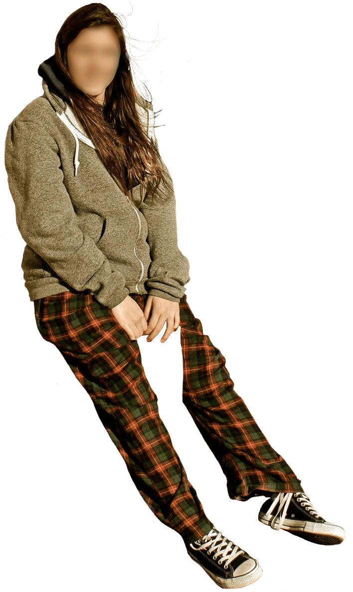 A photo of me wearing plaid pajama pants and a gray zippered sweatshirt. Converse are on my feet. My hair is longer.
